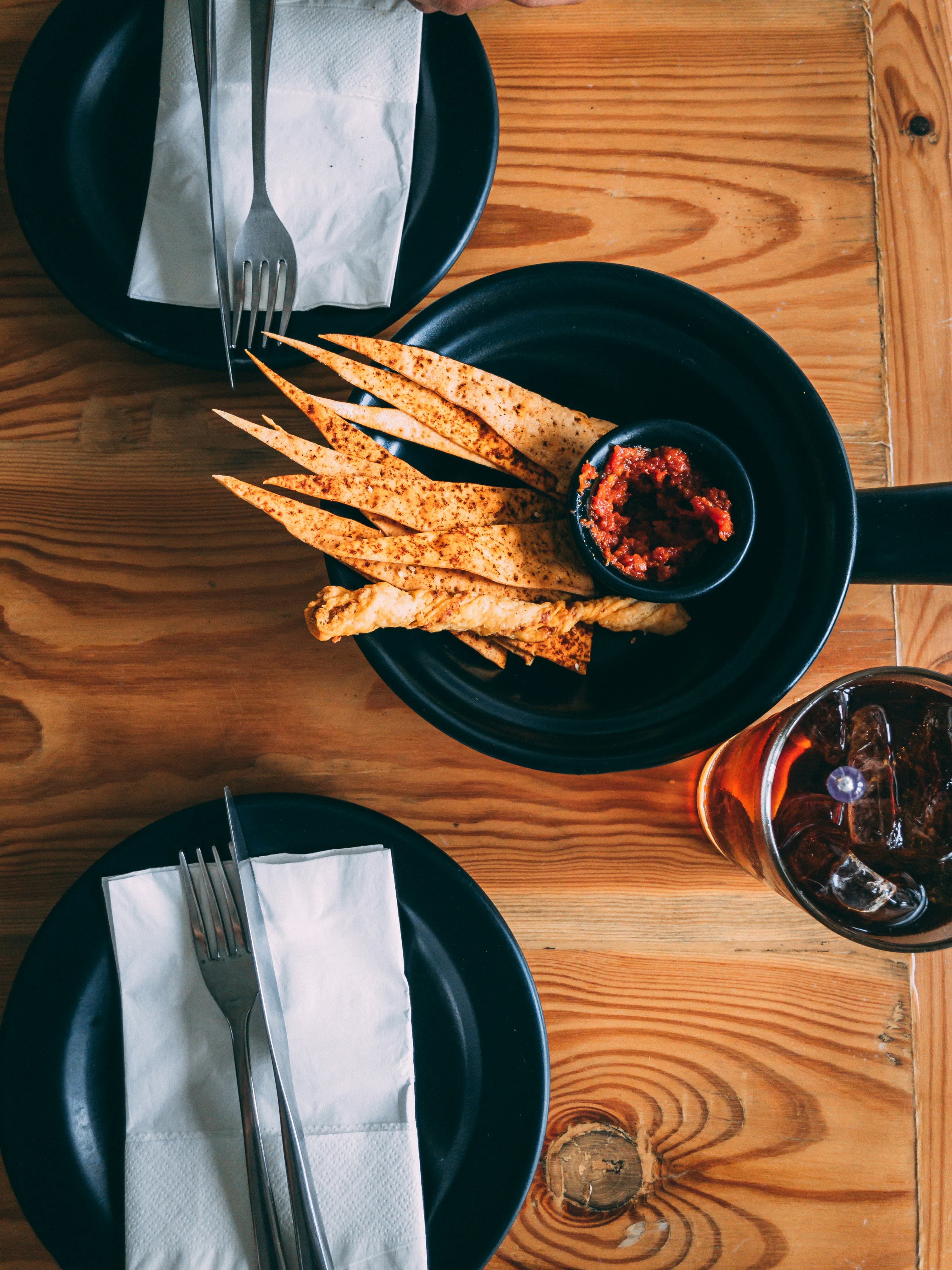 Snack chips in a bowl with dipping sauce on a wooden table