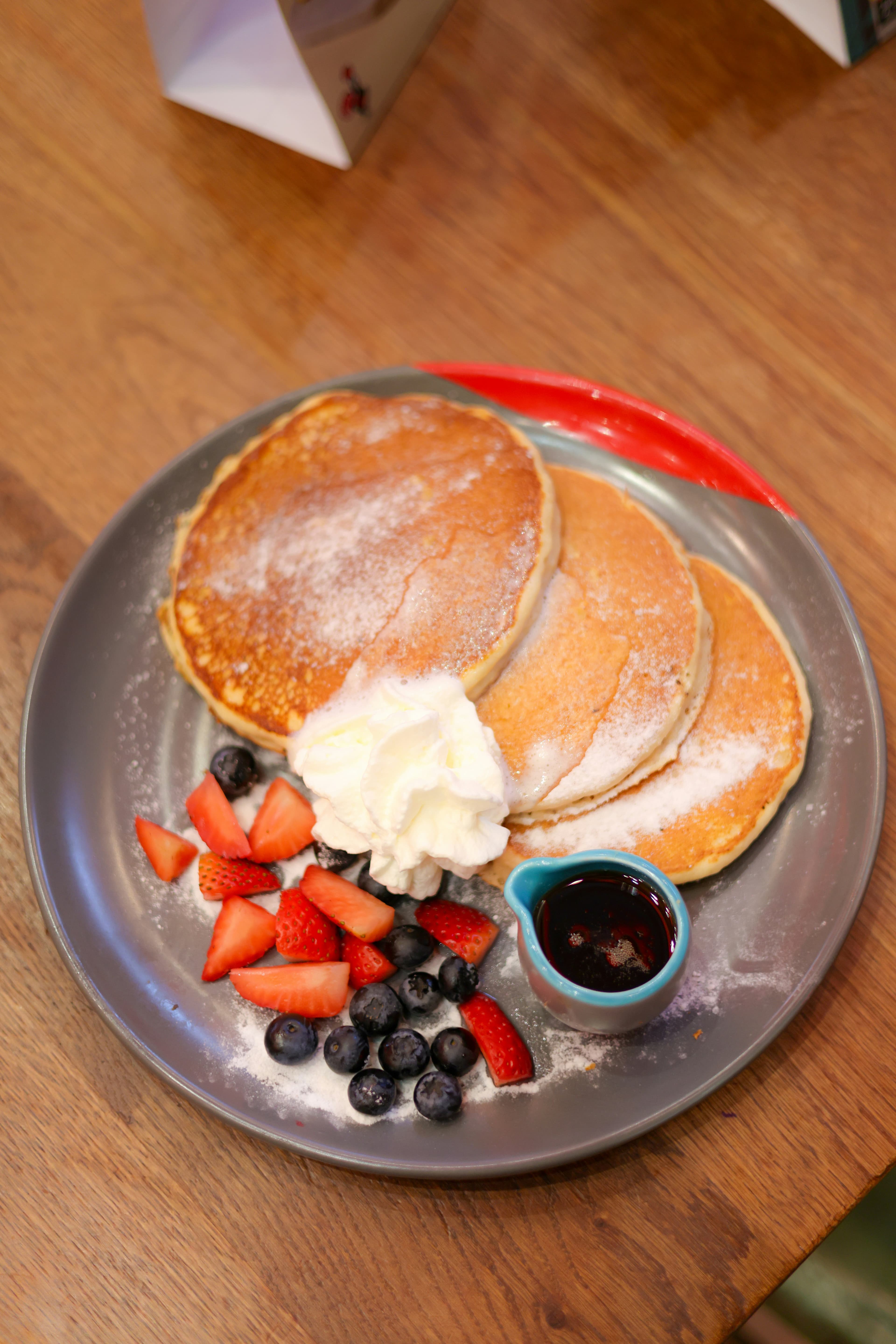 Pancakes with fresh berries and maple syrup on a plate